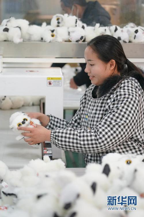 区五里镇朝阳社区一家毛绒玩具社区工厂内,一名工人在检验产品商标